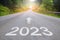 2023, concept photo of asphalt road. 2023 Year Calendar cover with summer forest and road. Optimistic landscape with sun dawn on