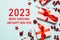 2023 Happy New Year and Merry Christmas. Christmas background design with garland, realistic gift box, balls and shiny