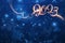 2023 holiday festive background light writing golden text on blue backdrop with blurred bokeh lights and glittering dust