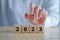 2023 new year challenge goal and target. Hand holding dartboard icon with 2023 word on wooden blocks.