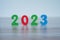 2023 standing colored block numbers on light wooden and white background