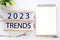 2023 trends on wooden box, Blank paper notebook and pen on white table background, new year business trend mock up, template, copy