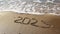 2023 year written on sandy beach sea. Top view.