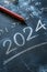 2024 date handwritten in a chalk writing text script on a wooden black chalkboard