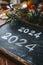 2024 date handwritten in a chalk writing text script on a wooden black chalkboard