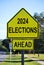 2024 Elections ahead in a traffic road sign on the side of street.