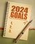 2024 goals list in a notebook, setting New Year goals and resolutions