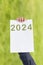 2024, Man holding cardboard with number 2024 on green background. Happy New Year