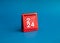 2024 numbers year with target dart icon on red small desk calendar cover standing on blue background.