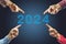 2024, People pointing to the number 2024 on blue background. Happy New Year