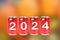 2024, Red soda cans with the number 2024 on orange background. Happy New Year