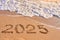 2025 year written on sandy beach sea at sunny day