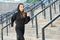 20s attractive female runner jogging on stairs outdoors