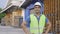 20s happy Indian distribution shipping depot worker looking at camera and smile. Male worker in hard helmet at