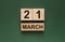 21 march inscription on wooden calendar on green background