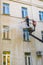 22.05.2019 Russia, Moscow. The employee of municipal services washes a facade of the multi-storey building by means of the high-