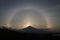 A 22 Â° halo is an optical phenomenon that belongs to the family of ice-crystal halos. Halo effect before sunset over Agung volcan