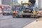 26.06.21. Kyiv, Ukraine. A team of road workers is laying fresh asphalt with industrial road machinery on a city street
