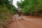 28 DECEMBER 2016, Vietnam, Can Txo. Dirt mud road in jungle of Vietnam after rain, two people on motorbike