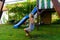 3-5 year old blond girl having fun on a swing outdoor. Summer playground. Girl swinging high. Young child on swing in