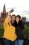 3 black haired latin women, sisters on outdoor terrace taking selfie with view of san miguel de allende parish in guanajoato mexi