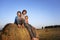 3 boys in a haystack in the field