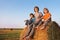 3 boys in a haystack in the field