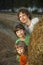 3 boys in a haystack in the field
