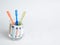 3 colorful toothbrushes stand in a jar where money is in euro
