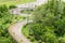 The 3 curve concrete road is go down from hill along with forest