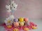 3 Easter bunnies in a white vase with a ceramic egg holder containing 6 Easter eggs on top of a bed of pink paper shreds with felt