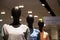 3 faceless black plastic female mannequins in a row at shopping mall
