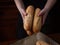 3 fresh baguettes only from the oven in the hands of the baker puts on the table