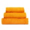 3 frotte towels orange color, bedroom towel white backgroung. Colorful orange bath towels isolated on white. Stack orange towels.