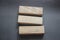3 long clean wooden blocks on dark gray. Education and business concept