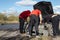 3 men repair damaged car during amateur drifting event