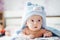 3 months baby boy weared in funny hat lying down on a blanket. A portrait of a cute blond baby