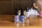 3 nail polishes stand on a table in front of a little girl