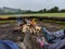 3 people in pairs of Wellington boots sitting around a campfire