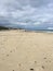 3 persons on empty beach with foot marks