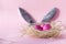 3 pink Easter eggs in nest, grey Bunny ears