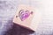 3 Pink Hearts Pierced By A Cupid Arrow Engraved On A Wooden Block On A Table