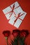 3 red roses with 2 gifts envelopes, red ribbons, certificates, invitation card inside. Craft concept. Red on the red background. C