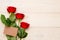 3 red roses with empty craft paper card
