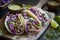 3 steak tacos with lime and cabbage on board