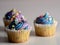 3 vanilla cupcakes with purple and blue frosting with confetti sprinkles on a white background, perfect delicious treat for a