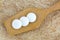 3 white medicines on wooden spoon with brown Mulberry paper back