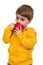 The 3-year-old boy in blue points drinks from a mug, isolated on the white