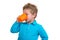 The 3-year-old boy in blue points drinks from a mug, isolated on the white