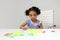 3-year-old Latina girl with brunette and curly hair plays with a game of letters and numbers for learning within the autism